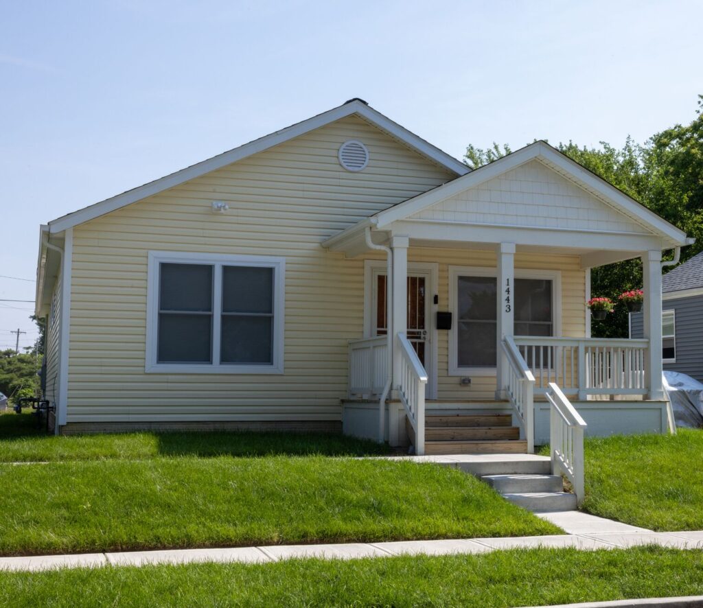 yellow house sitting on a bright green lawn