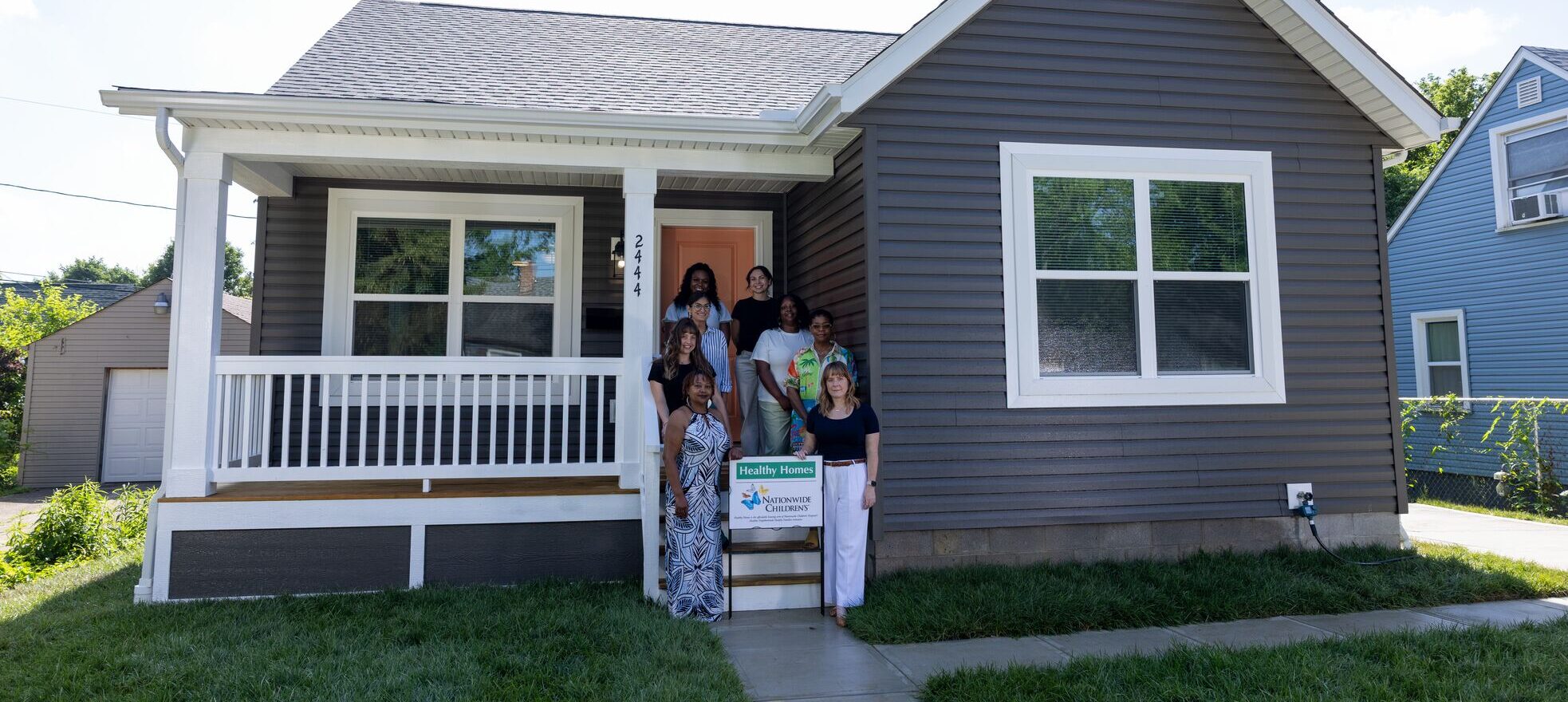 Staff of Healthy Homes standing on the porch of a house they remodeled