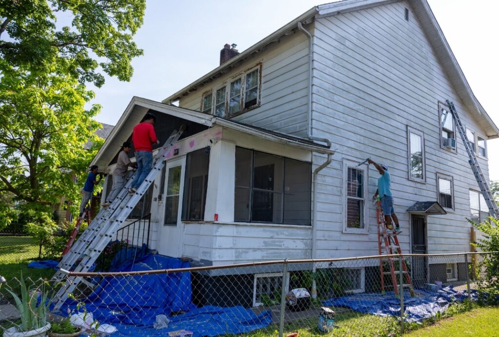 several men repairing a white house